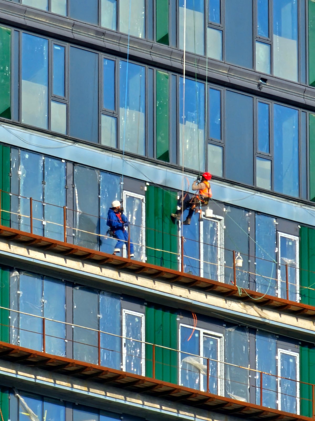 Workers rappel down building facade in Khimki, Russia