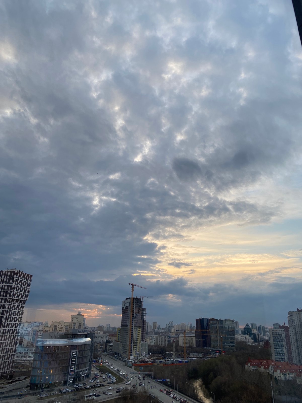 Window cleaner works on Yekaterinburg high-rise amid construction activity