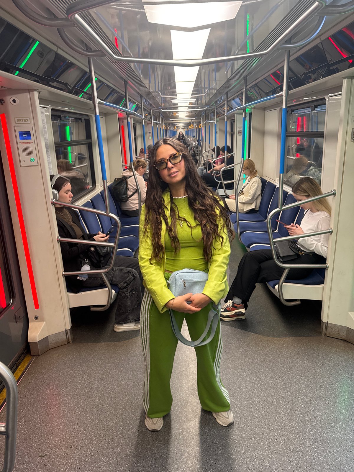 Woman in green tracksuit rides Kazan subway during morning commute