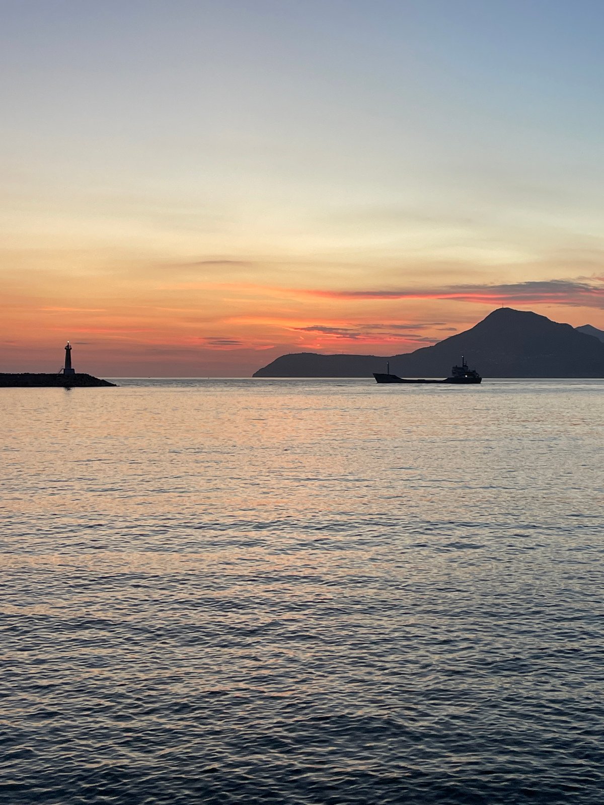 Adriatic sunset in Bar, Montenegro, lighthouse and mountains in view