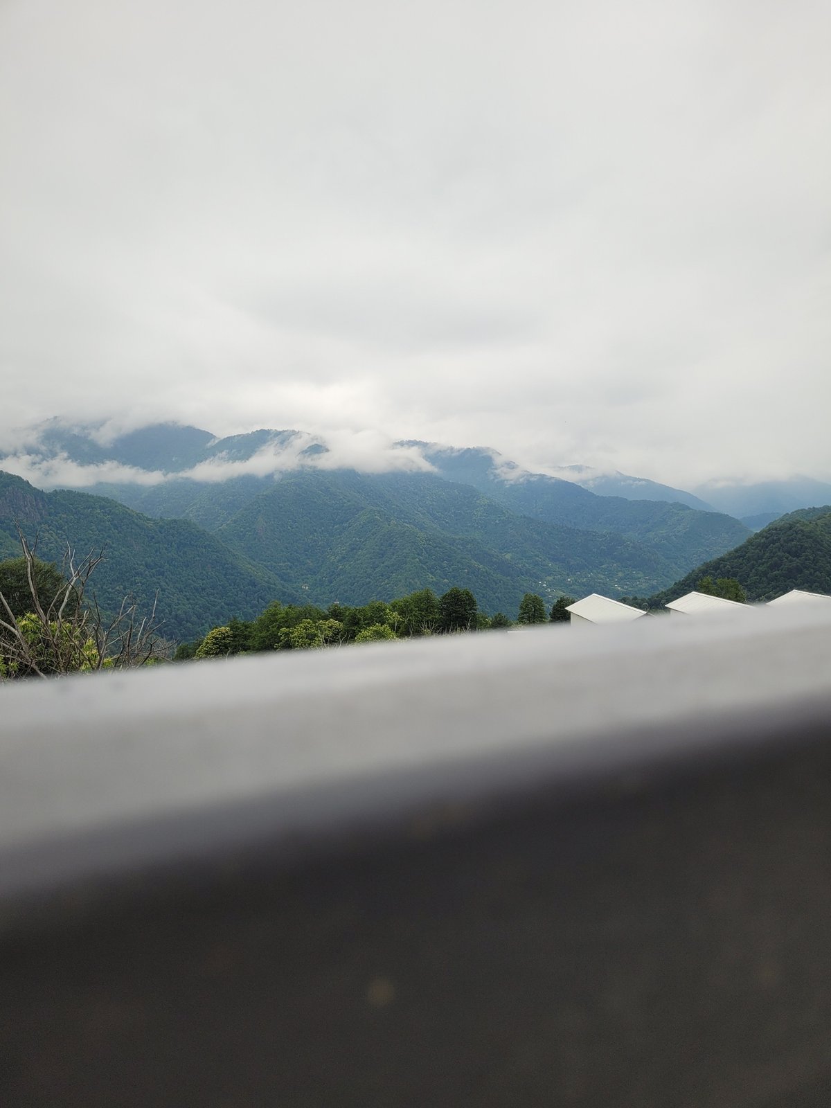 Construction and cloud-covered hills in rural Milisi, Georgia