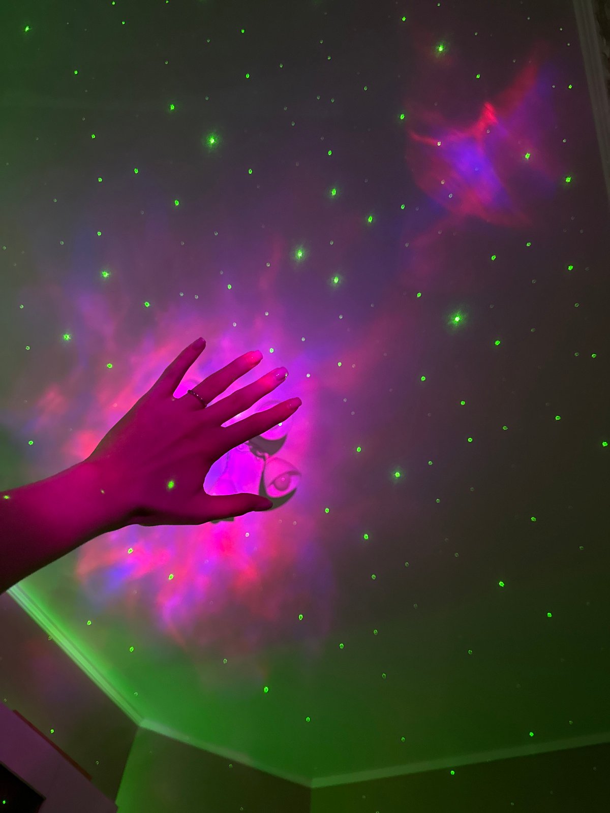 Cozy bedroom setup with galaxy projector, moon lamp, and skincare