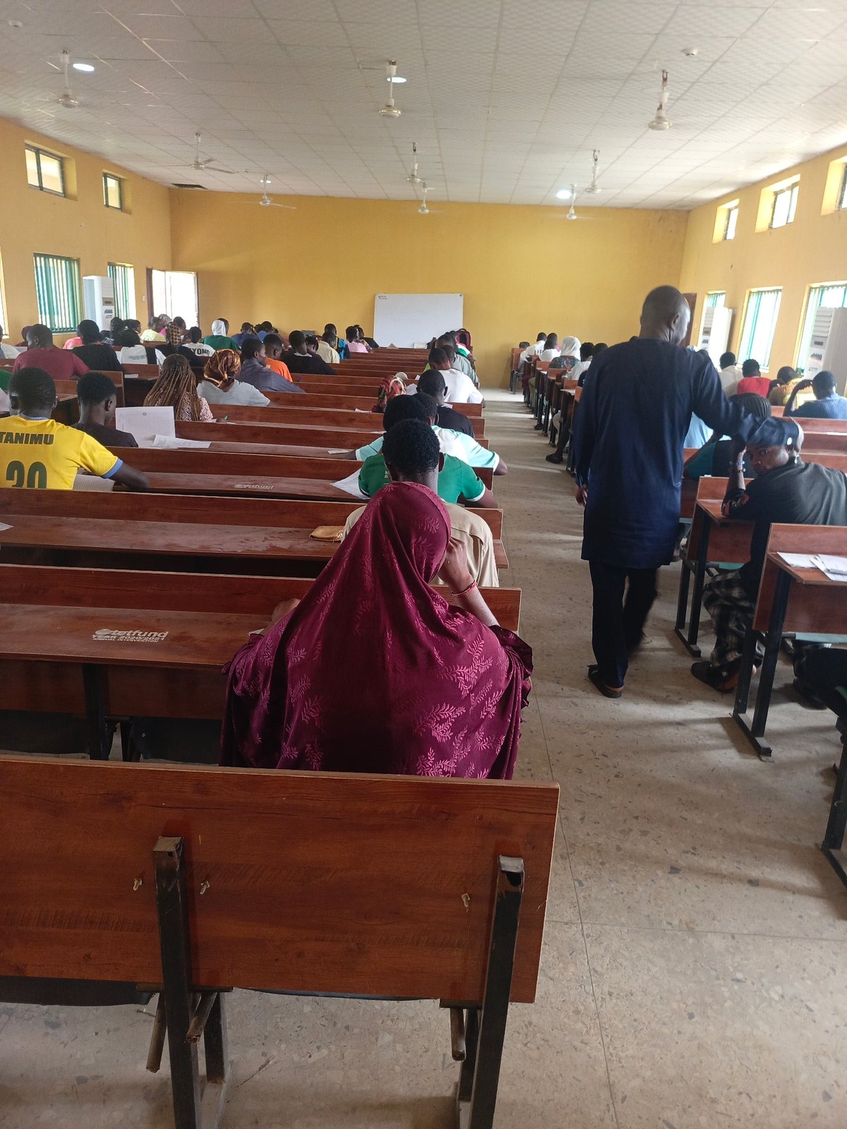 Students gather for exam or lecture in Akwanga classroom