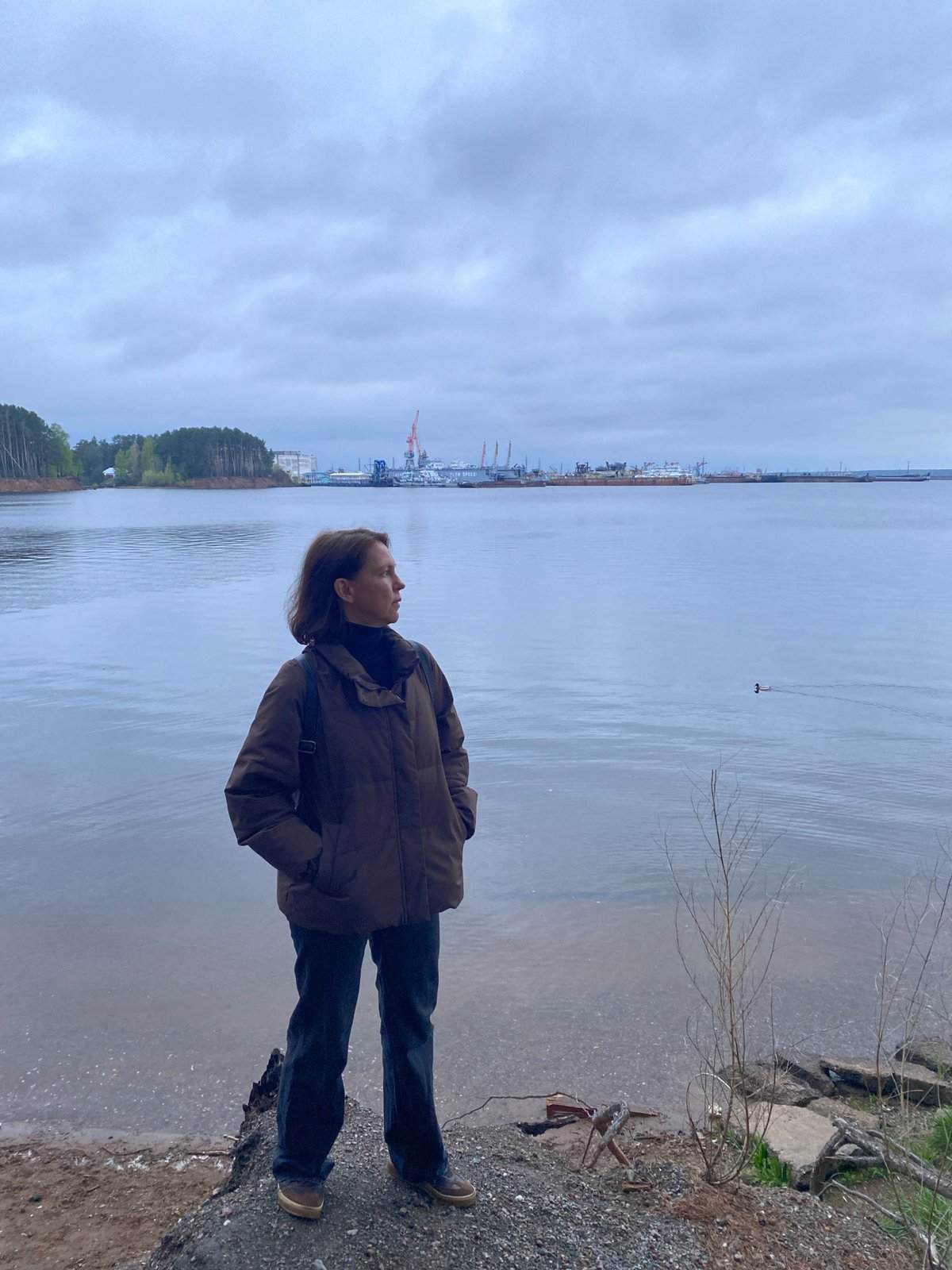 Person enjoys quiet riverside moments in Chaikovsky, Russia