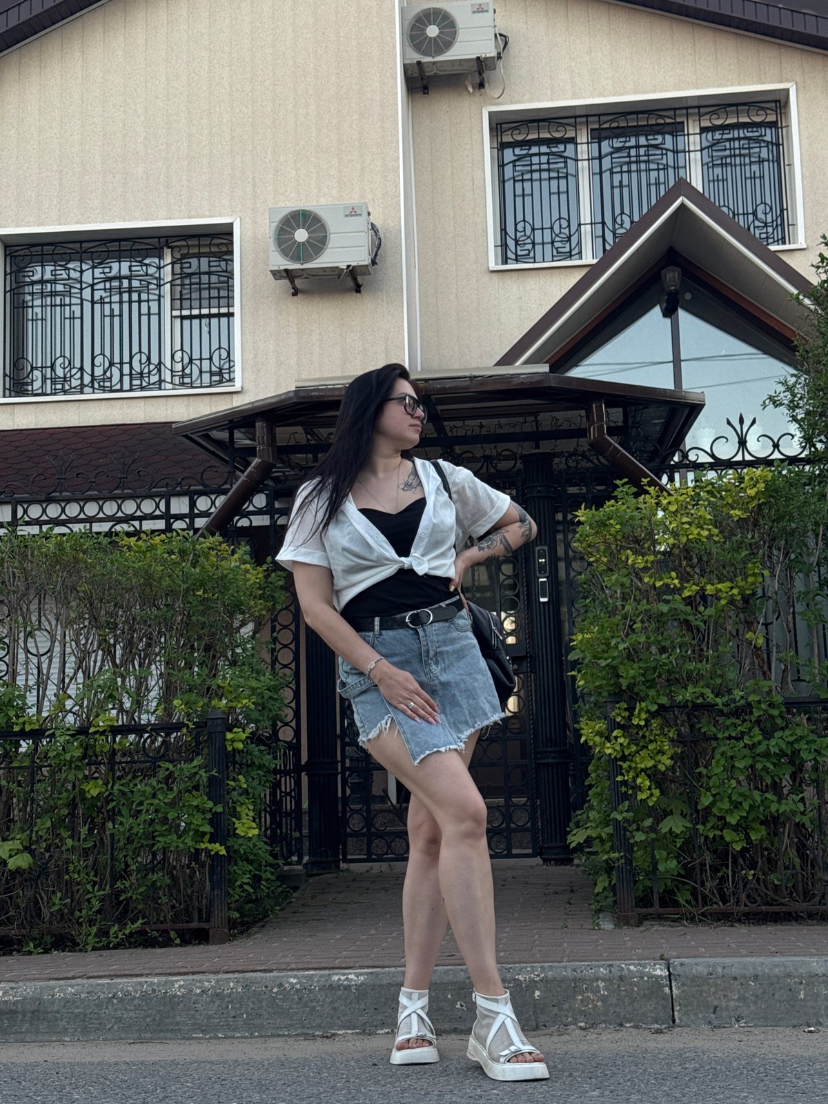 Woman photographs herself in residential neighborhood during afternoon walk