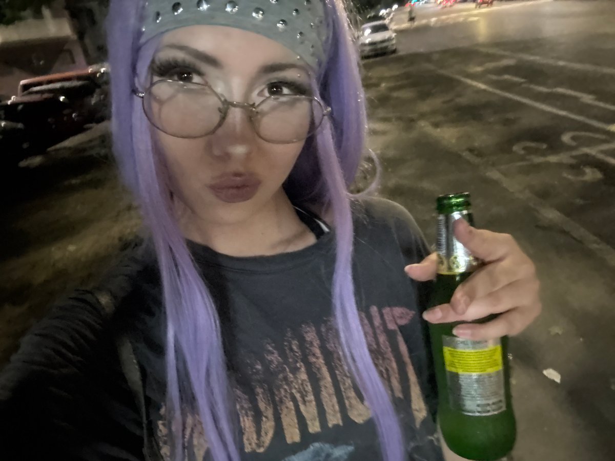 Purple-haired figure with green beer bottle, Milan night out
