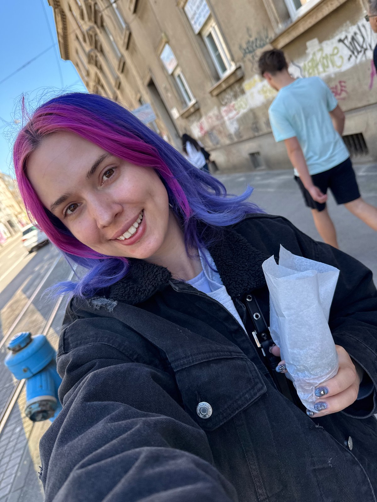 Purple-haired person photographed near Zagreb church on sunny morning