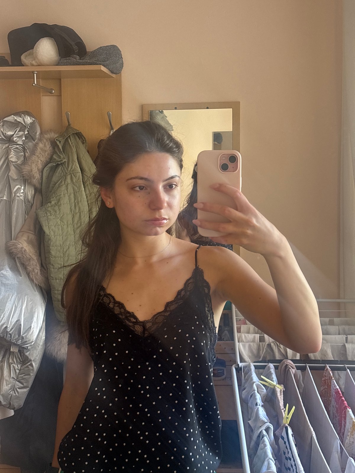 Mirror selfie in a Varna apartment, pink phone in hand.