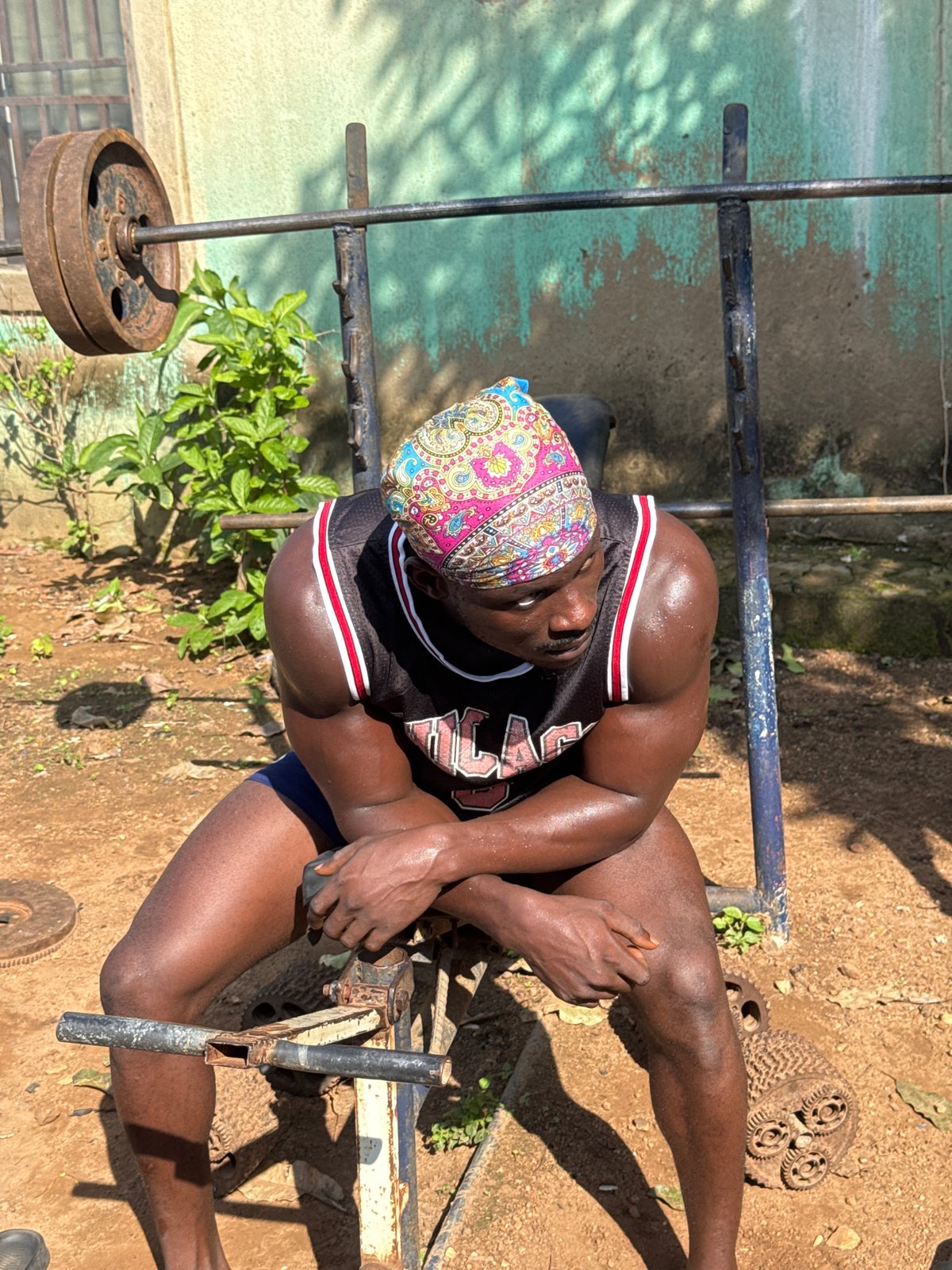 Outdoor fitness competition featuring arm wrestling and weightlifting in Nigeria