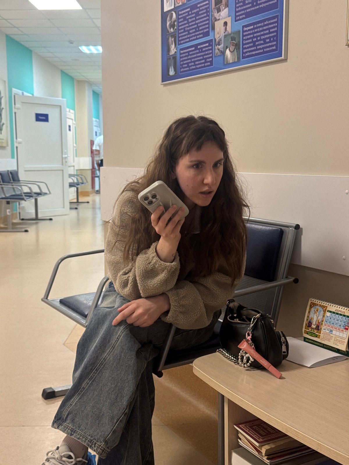Woman waits with phone in Moscow clinic area