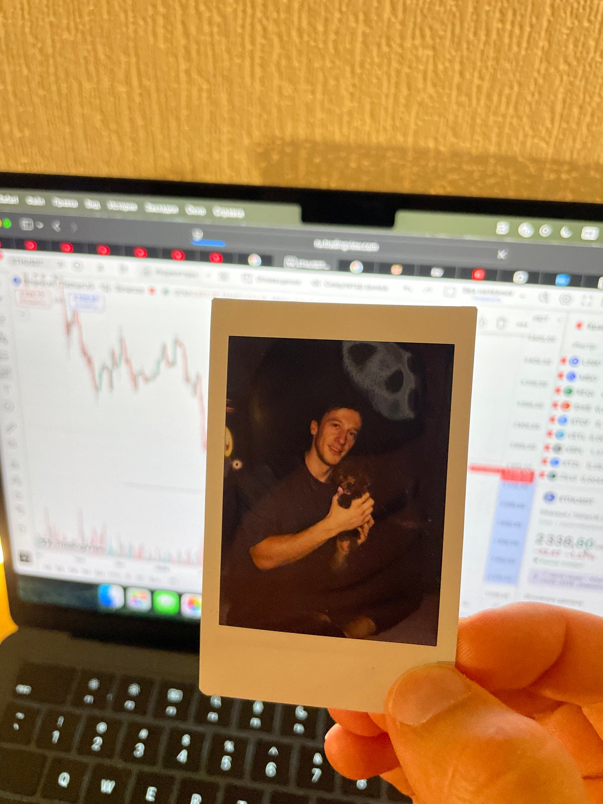 Person holds vintage photo over laptop in Russia