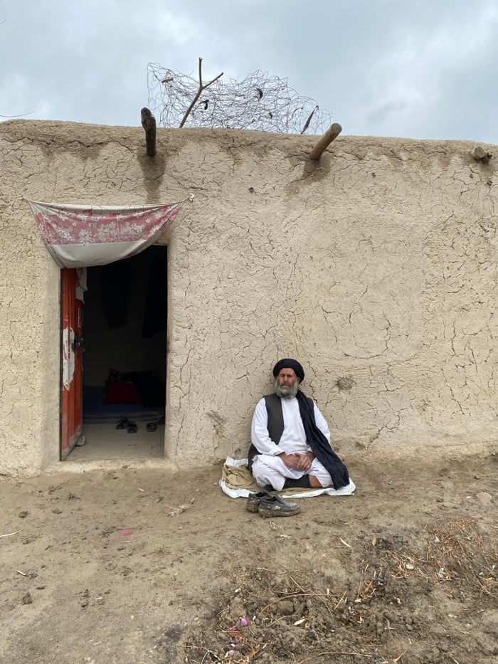 Elderly man rests outside rural home in Kandahar