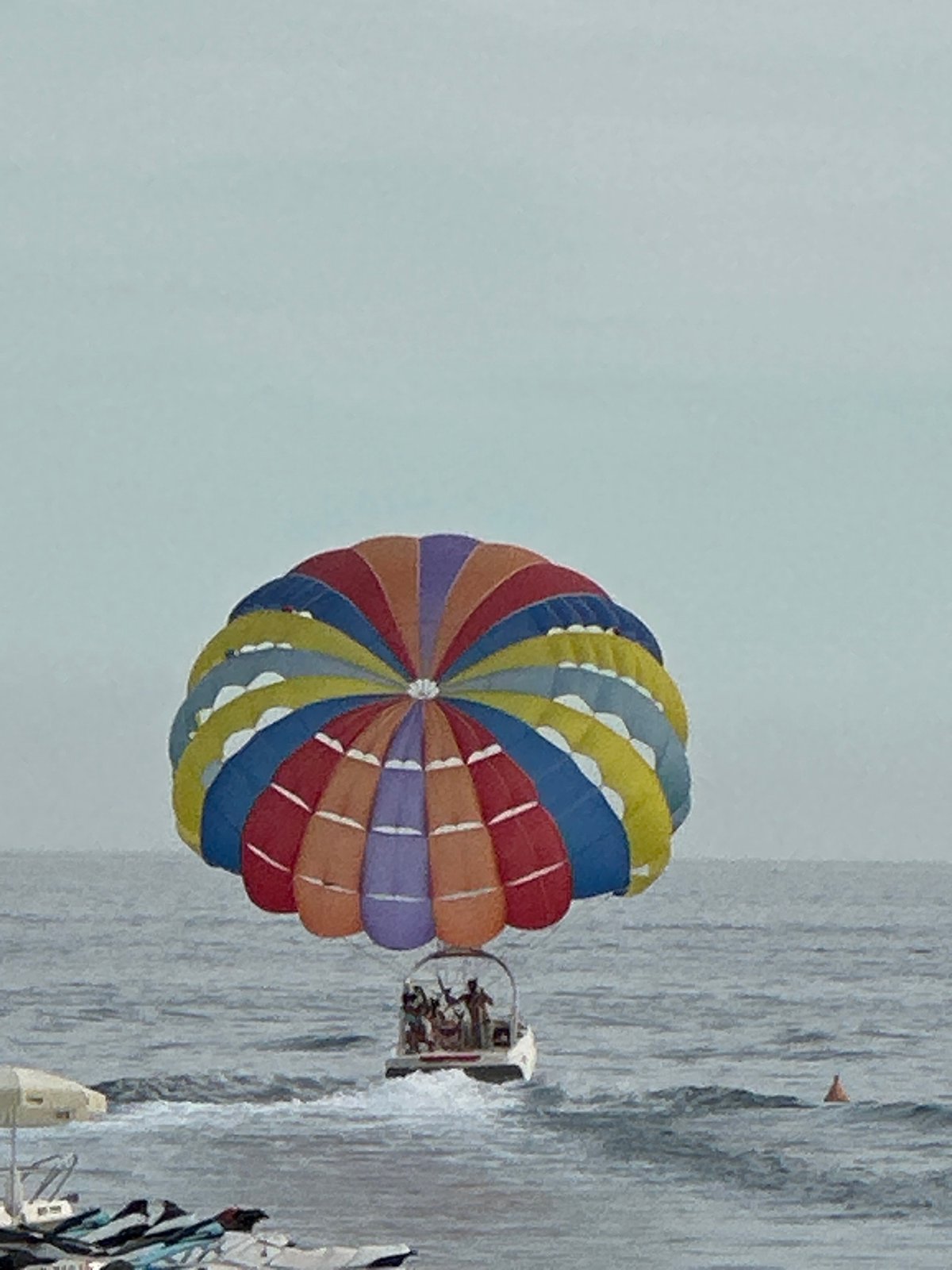 Colorful parasail floats above the Adriatic at Rafailovići