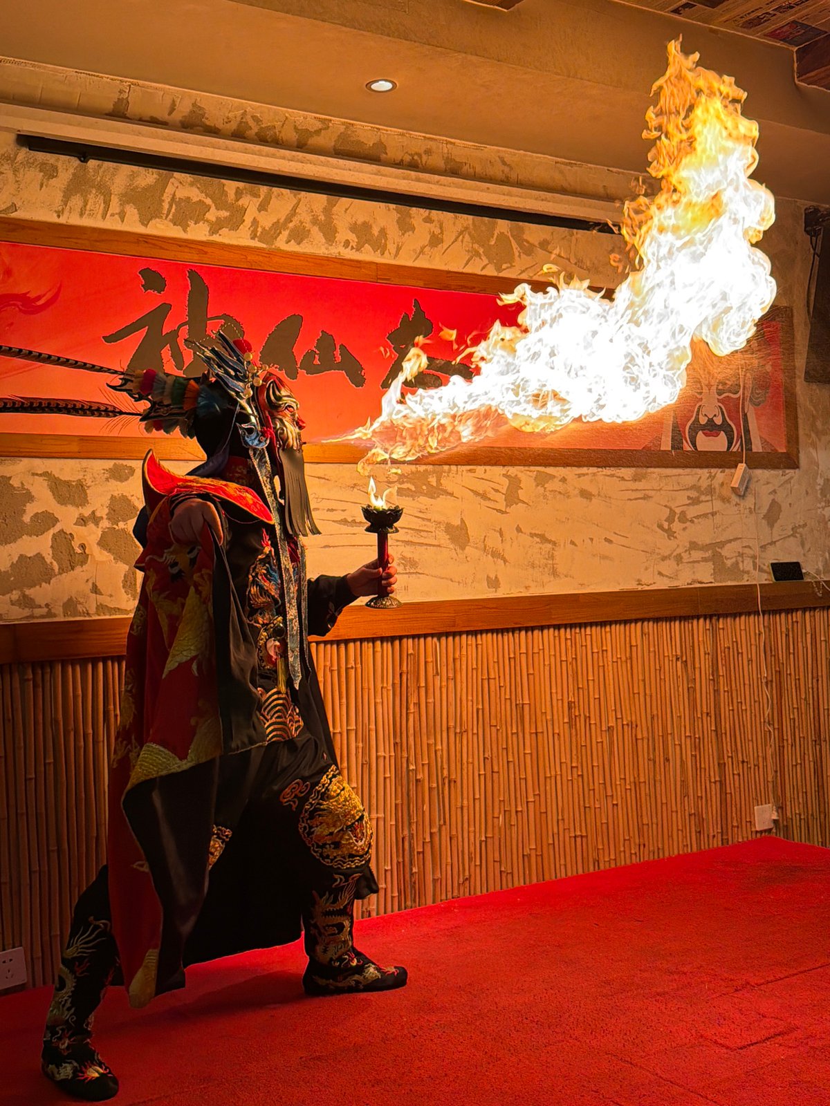 Ornate-costumed fire performer unleashes a dramatic flame plume