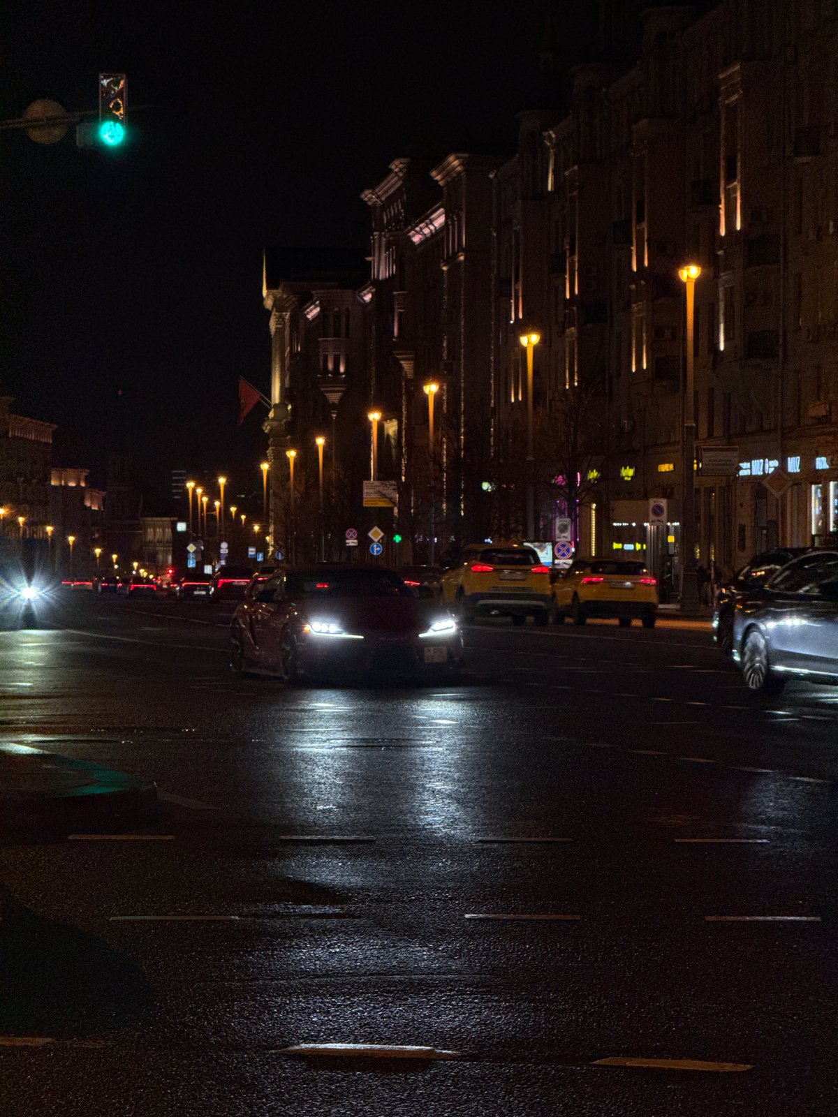 Moscow evening scenes show wet streets, classical architecture, holiday lights