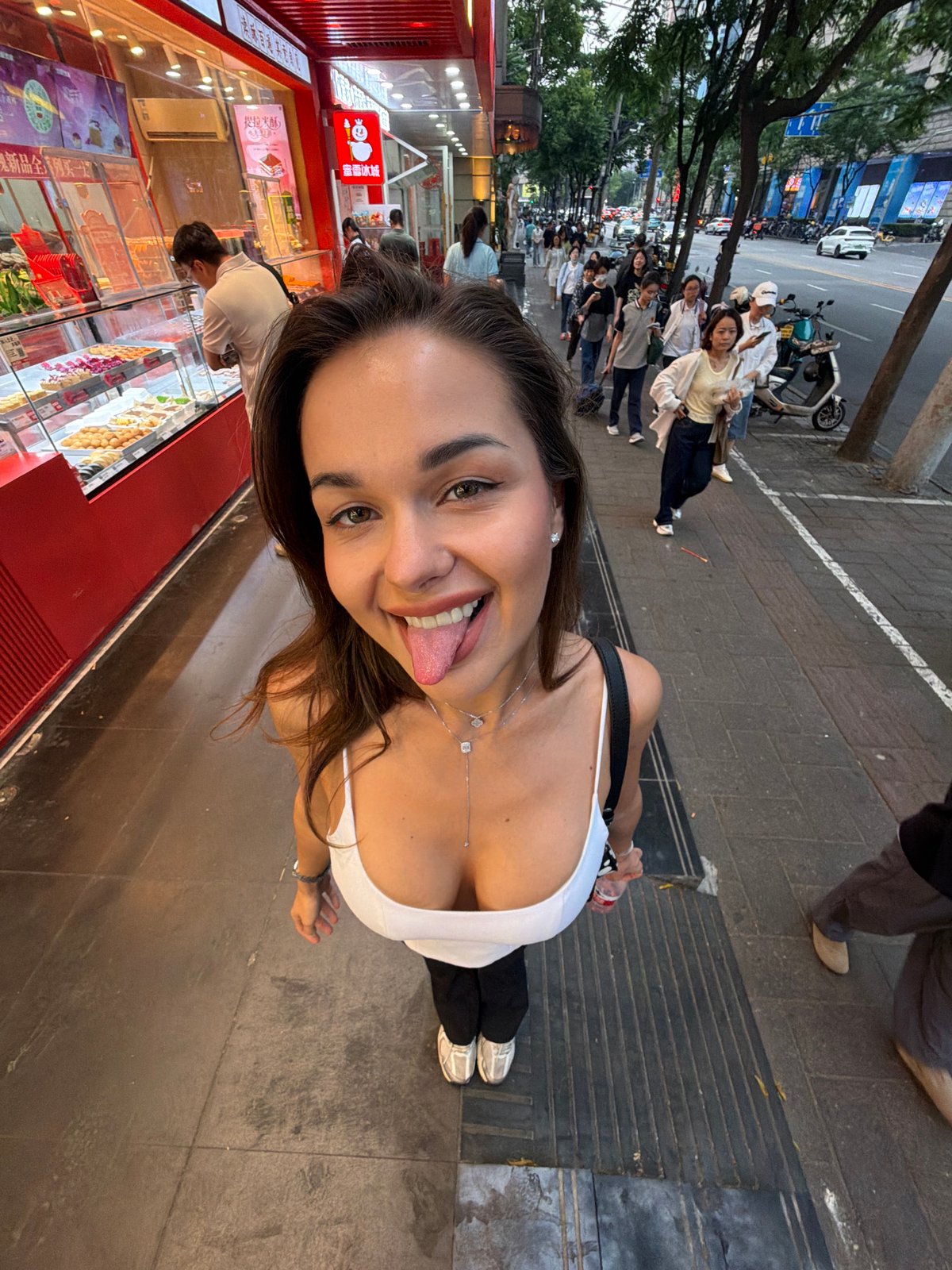Woman takes playful selfies on busy Shanghai street