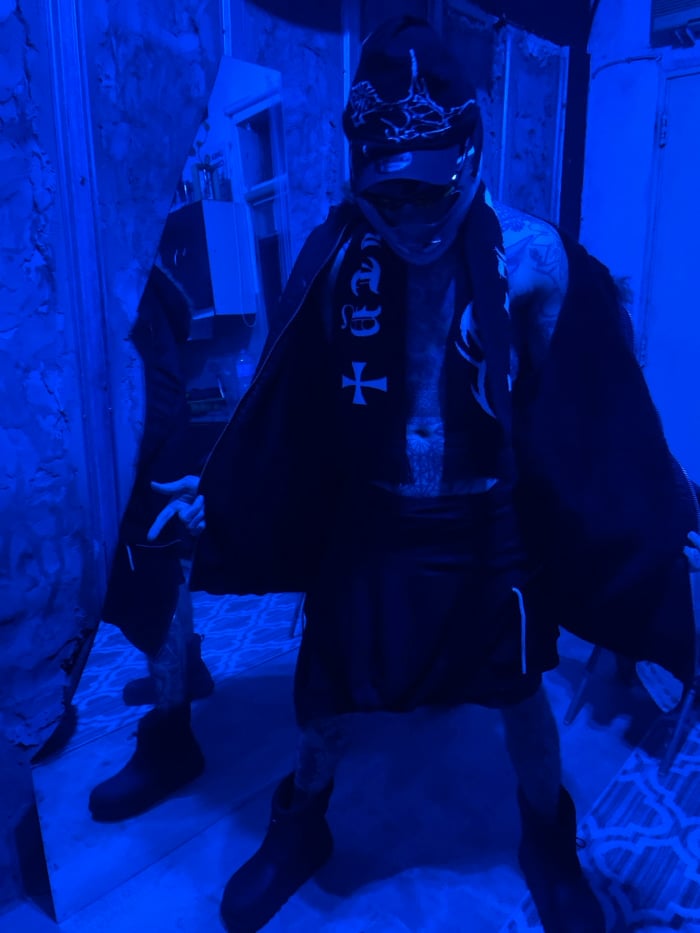 Masked individual spotted in blue-lit Buenos Aires room