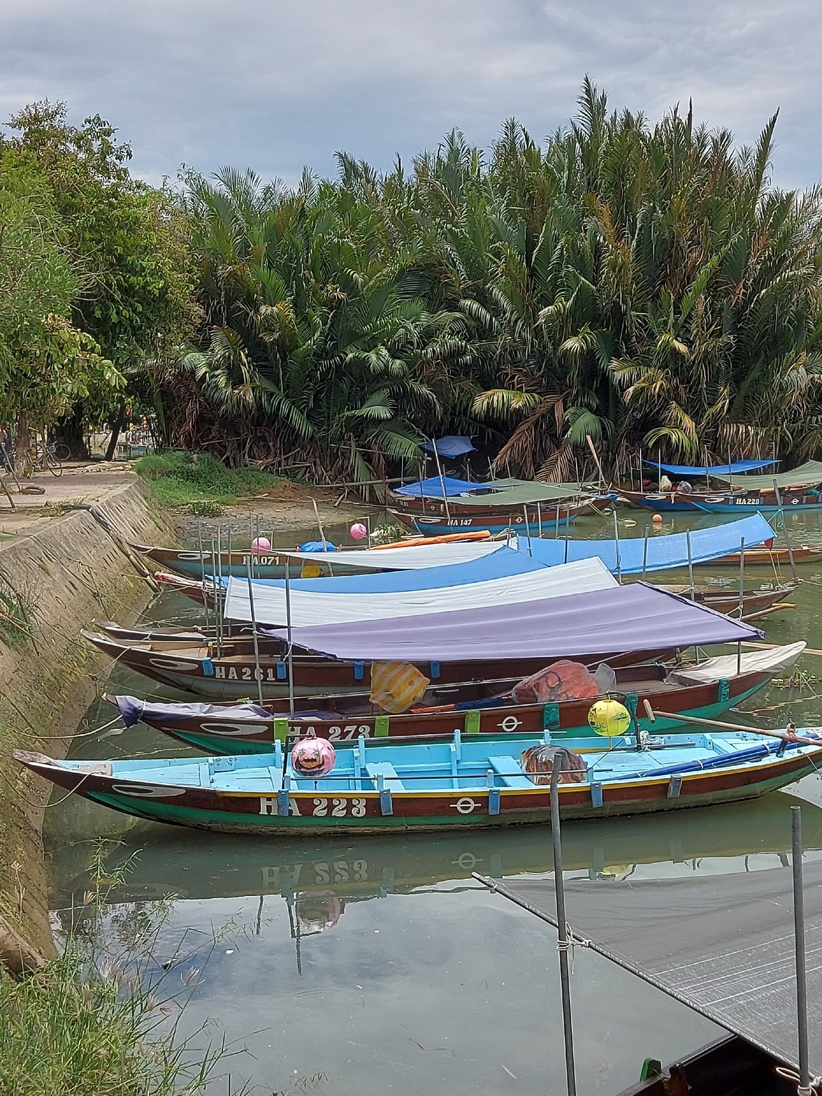 Hoi An's covered bridge and canal boats on a quiet morning