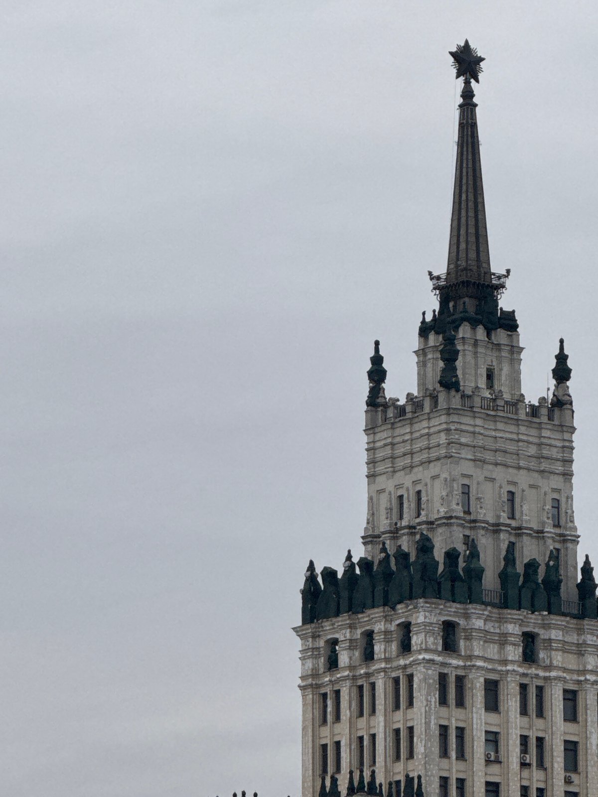 Moscow Stalinist skyscraper with Soviet star photographed under grey sky