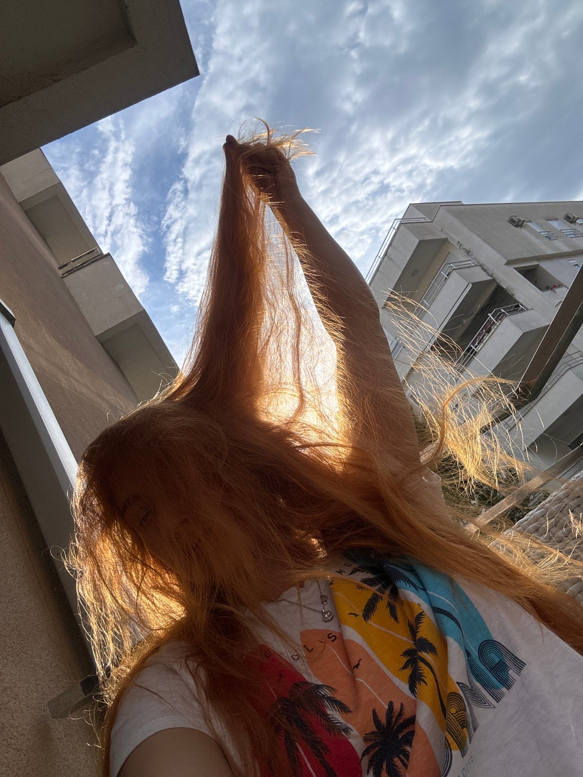 Woman takes selfies on Montenegro balcony during golden hour
