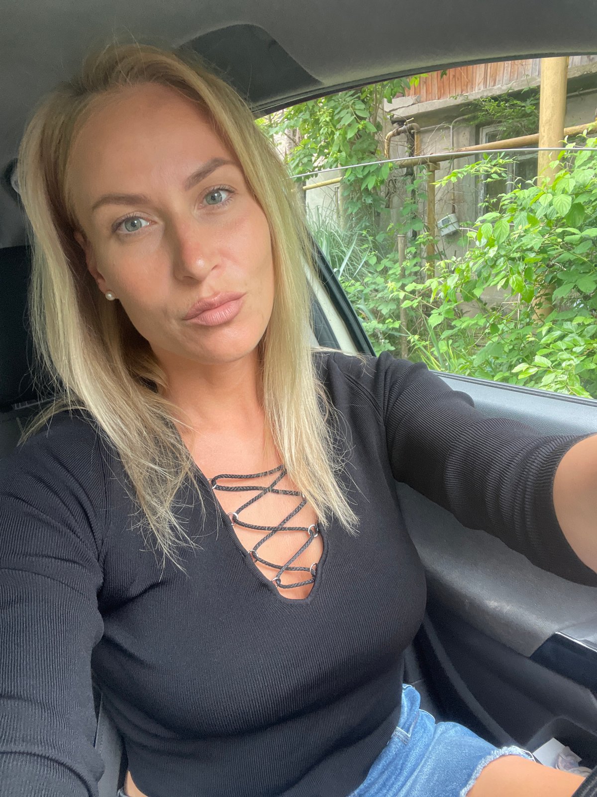 Woman in car, cow rests roadside in Baranovka