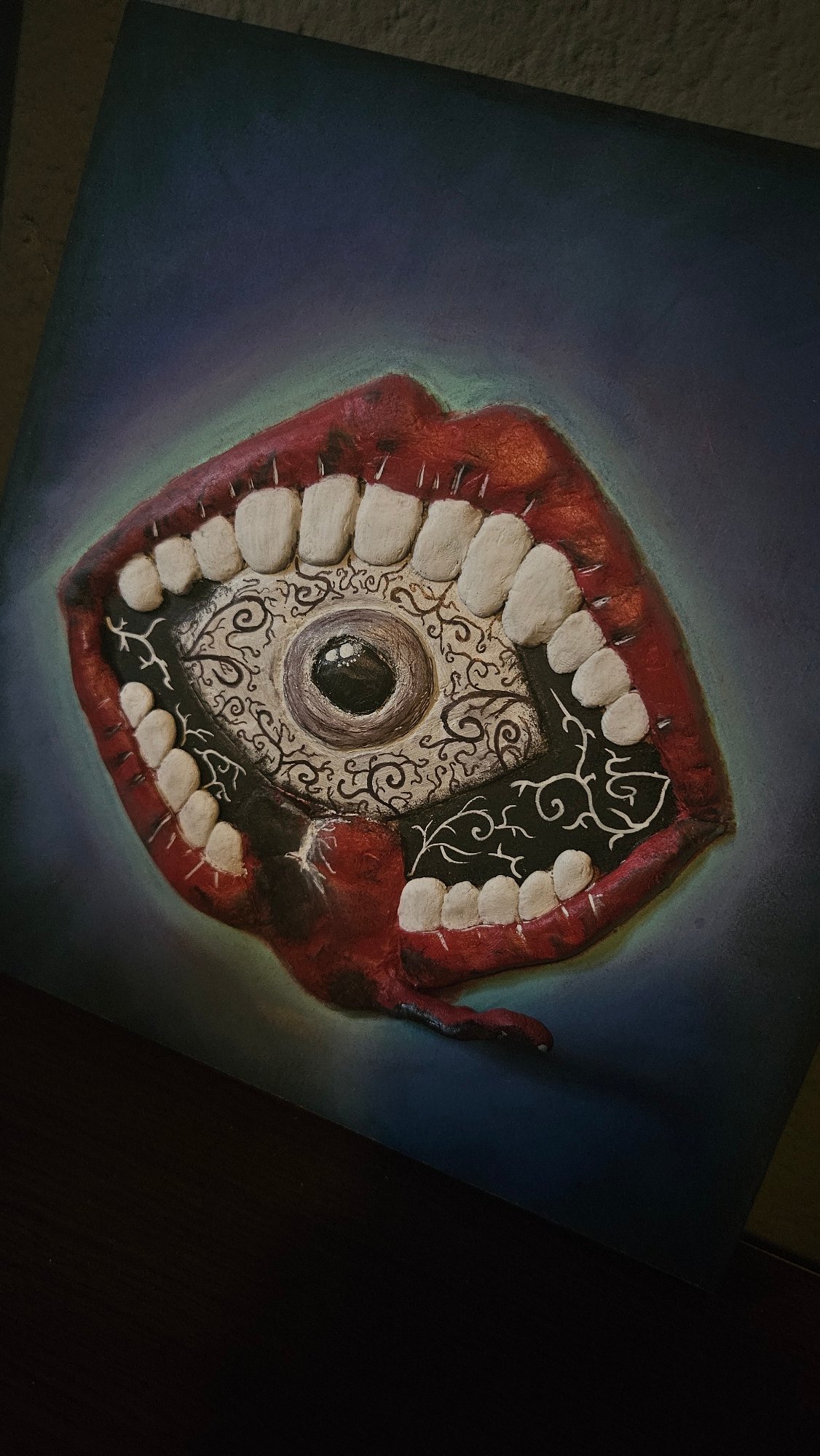 Dark artwork and novelty items photographed up close.