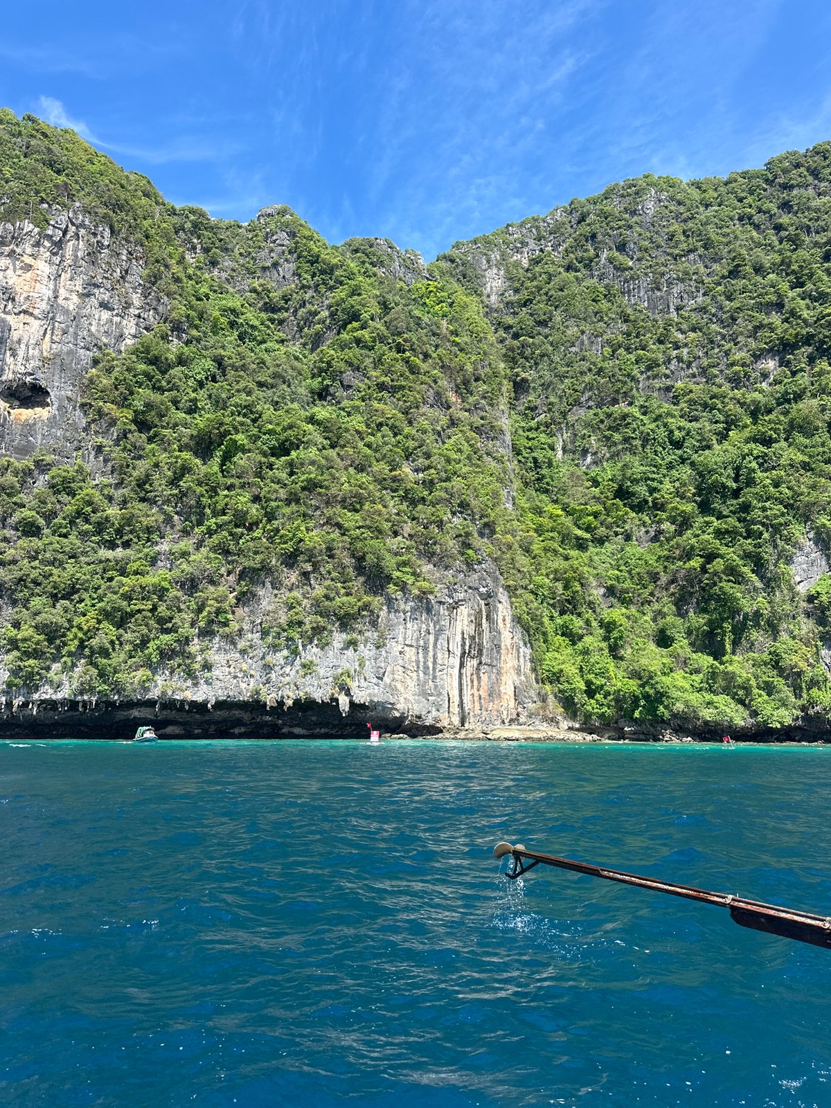 Longtail boat navigates limestone karsts off Haad Yao