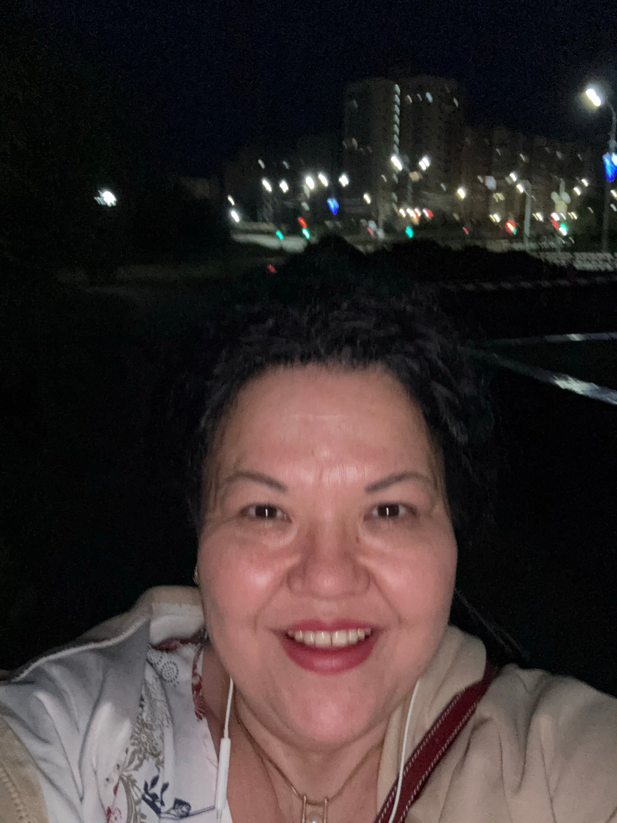 Woman captures nighttime selfies in urban setting