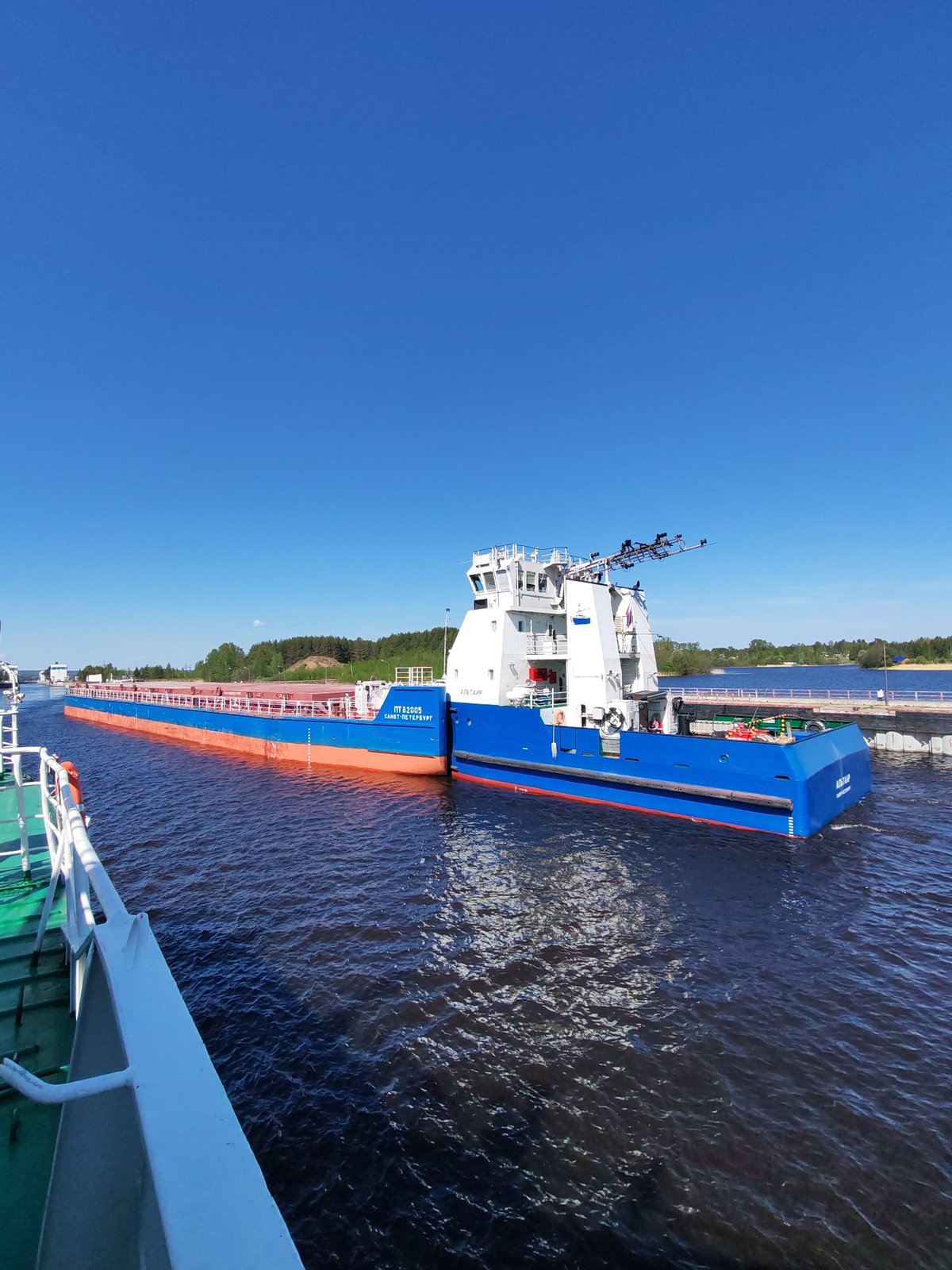Cargo ships navigate waterway near Белоусово, Russia