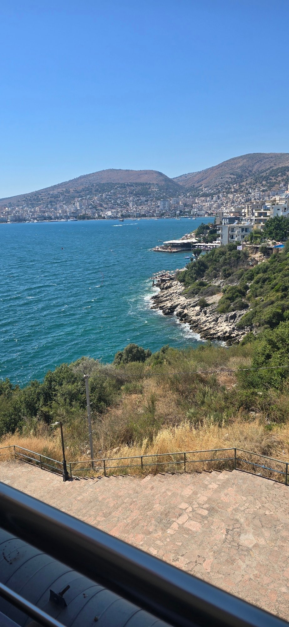 Saranda's coastline and hillside apartments on a clear afternoon