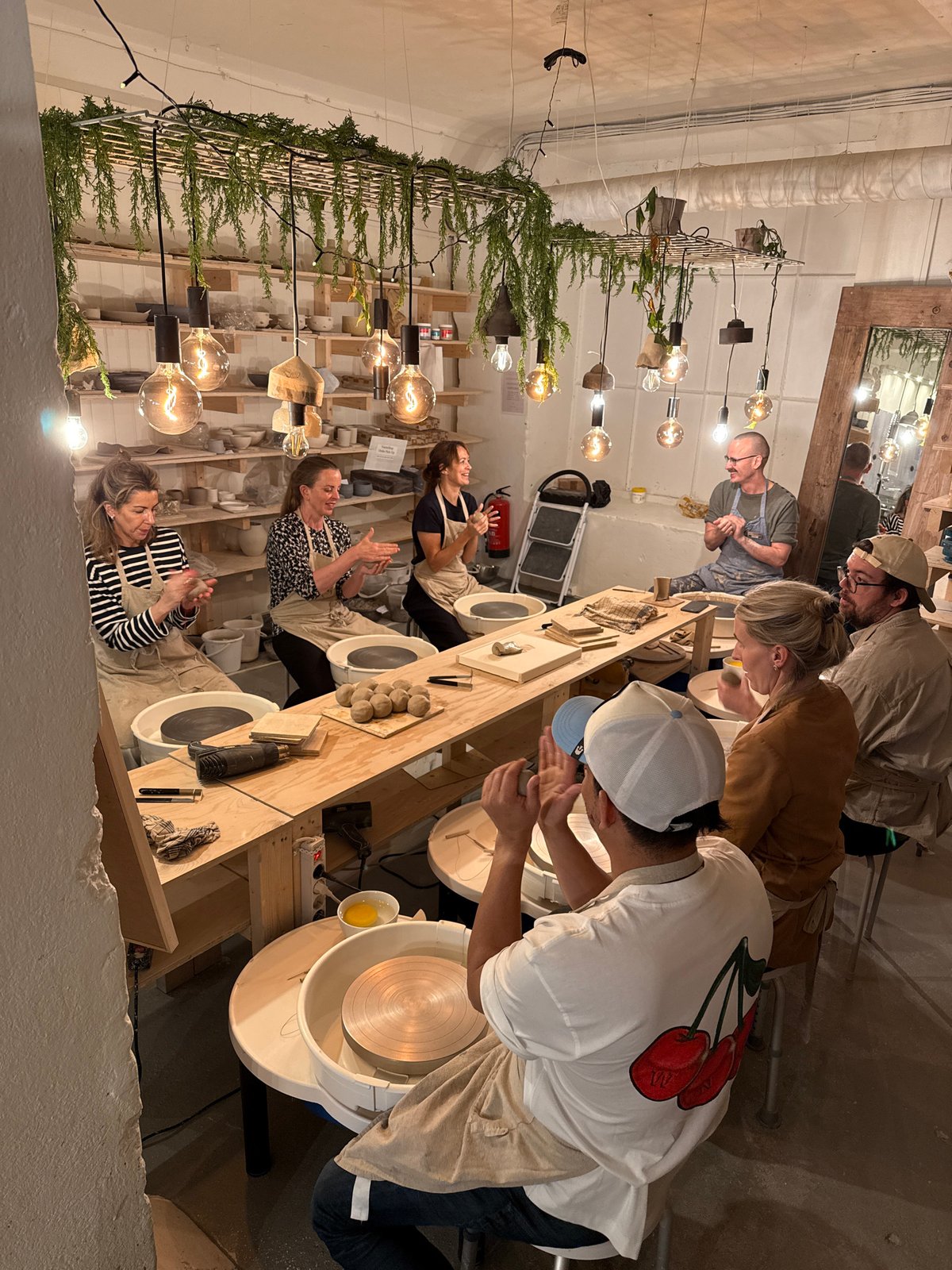 Pottery workshop in session with multiple participants crafting ceramics
