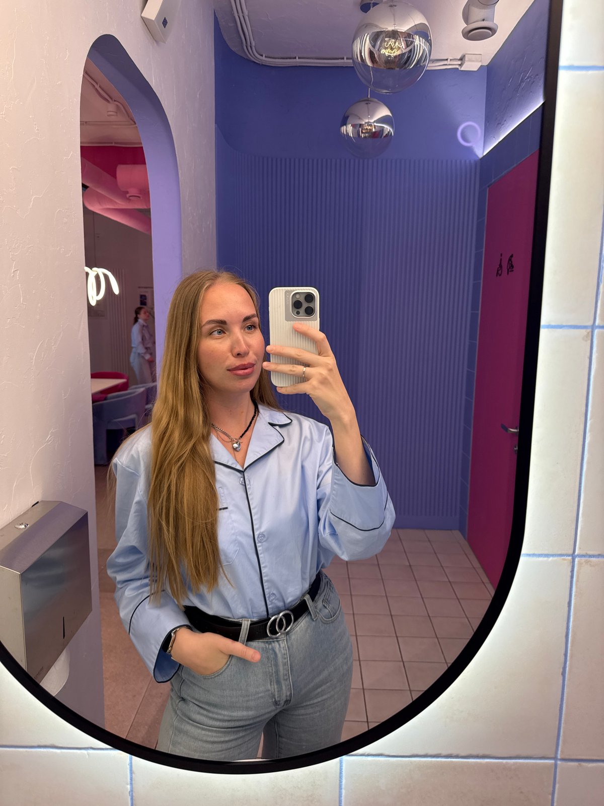 Woman takes mirror selfies in pink-themed Sochi restroom