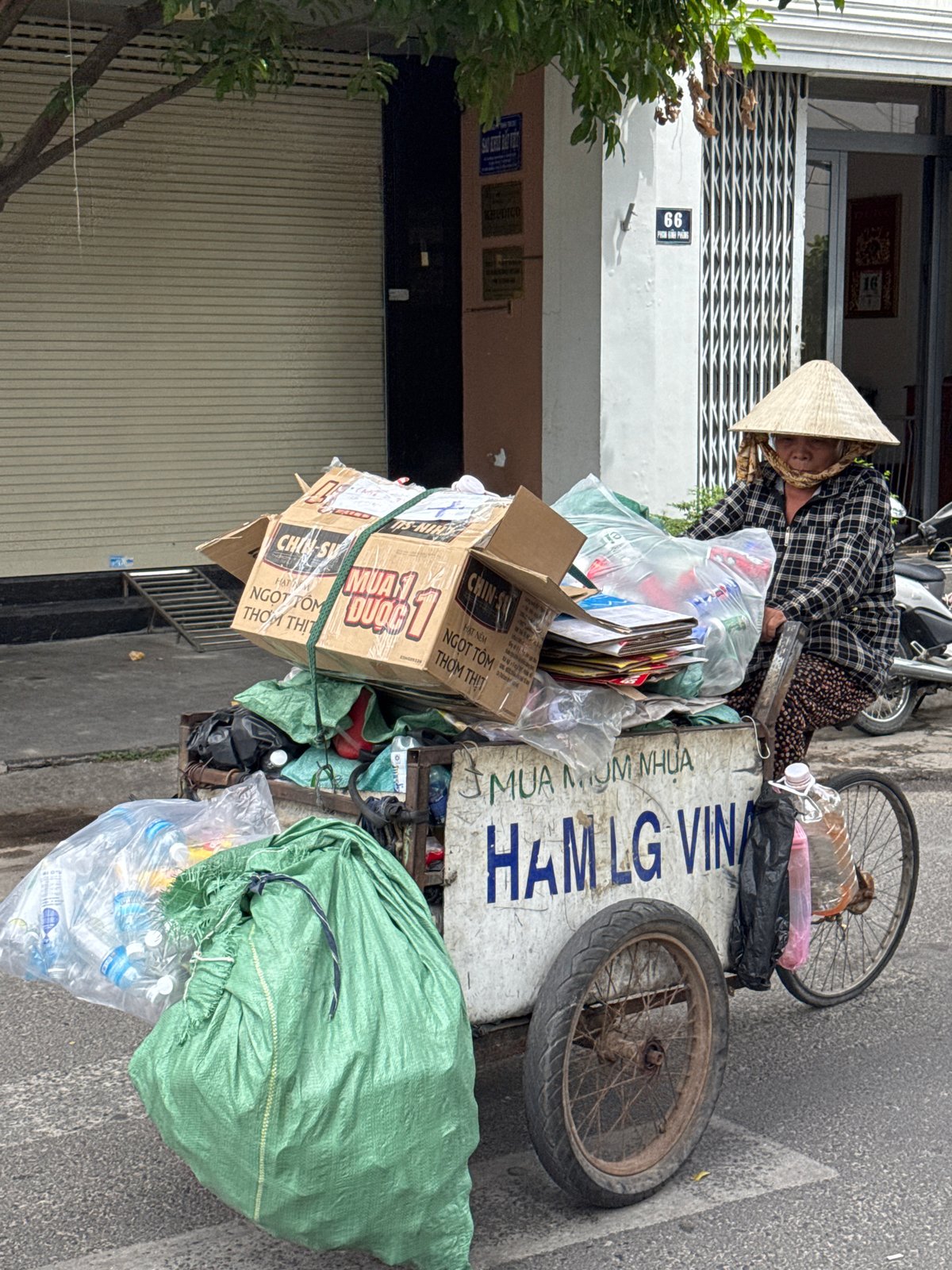 Recycling tricycles and street traffic on a Nha Trang block