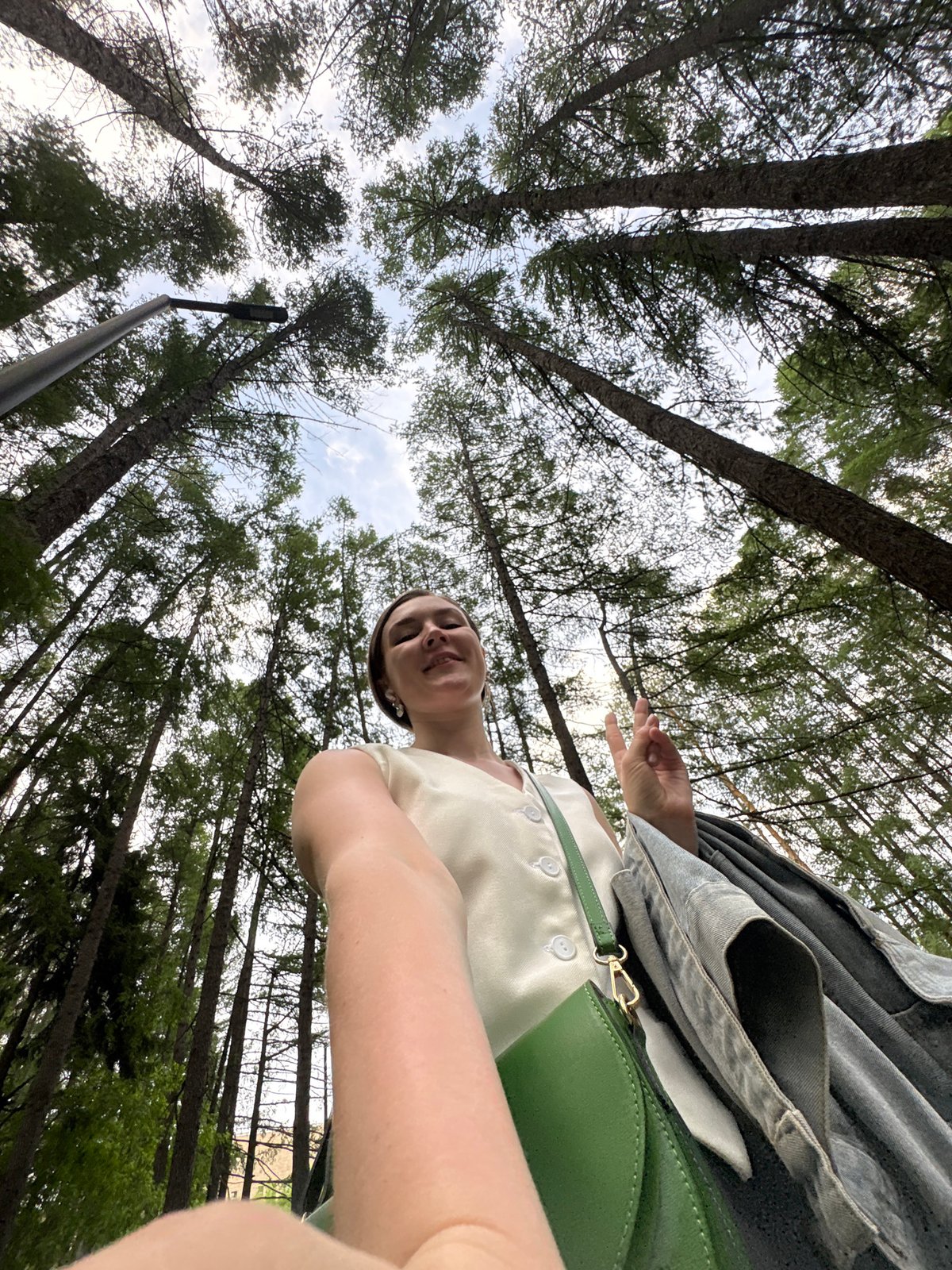 Woman takes outdoor self-portraits on forest path in Izhevsk
