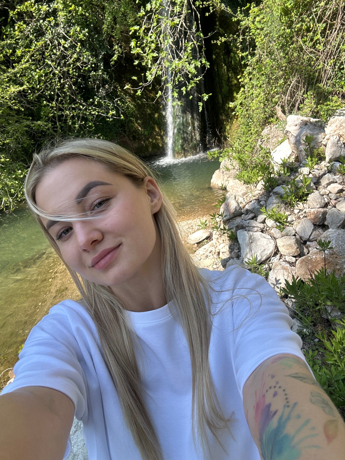 Tourist photographs waterfall selfie in Montenegro countryside