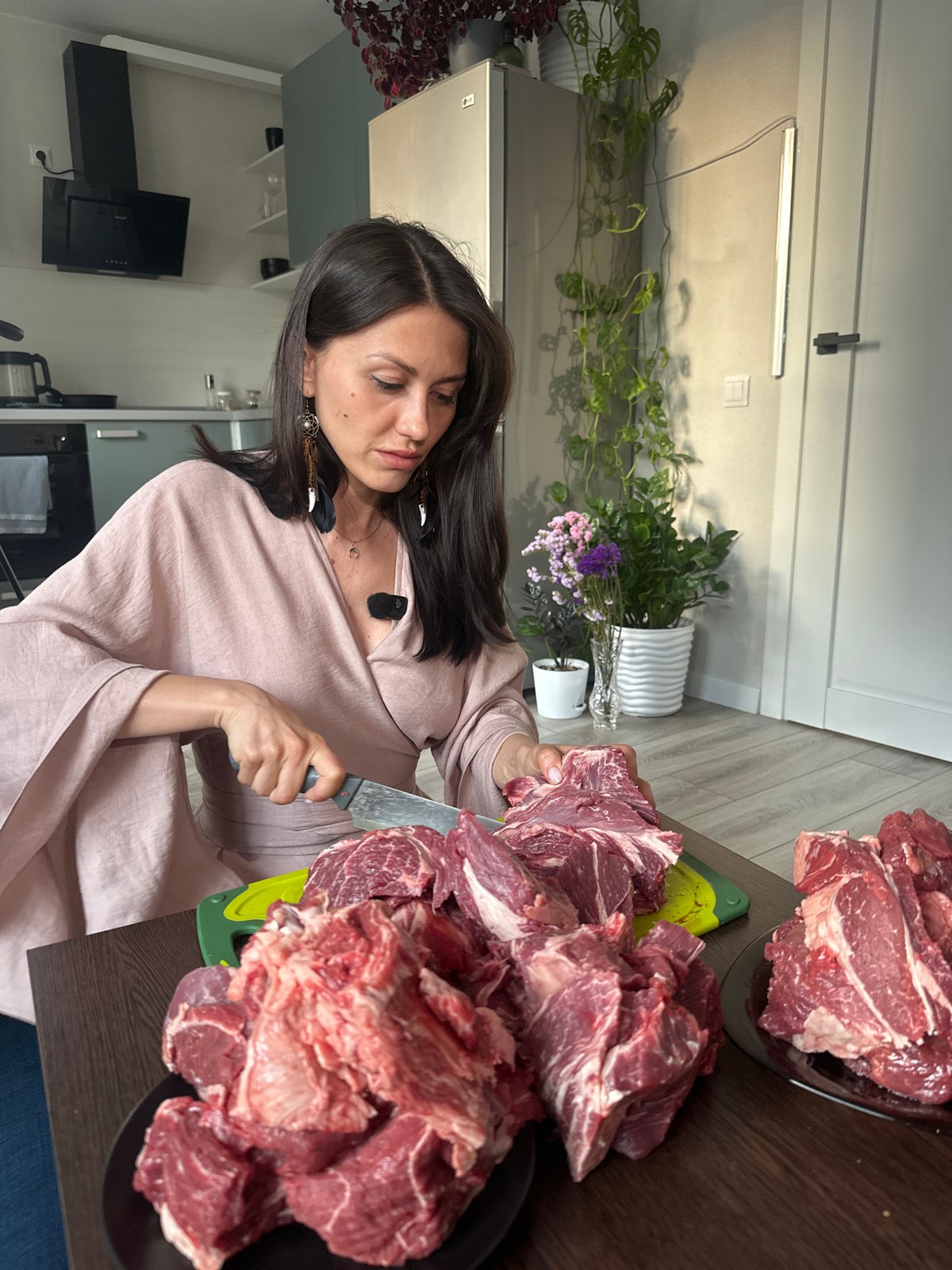 Woman prepares large meat portions in Sinyavino kitchen