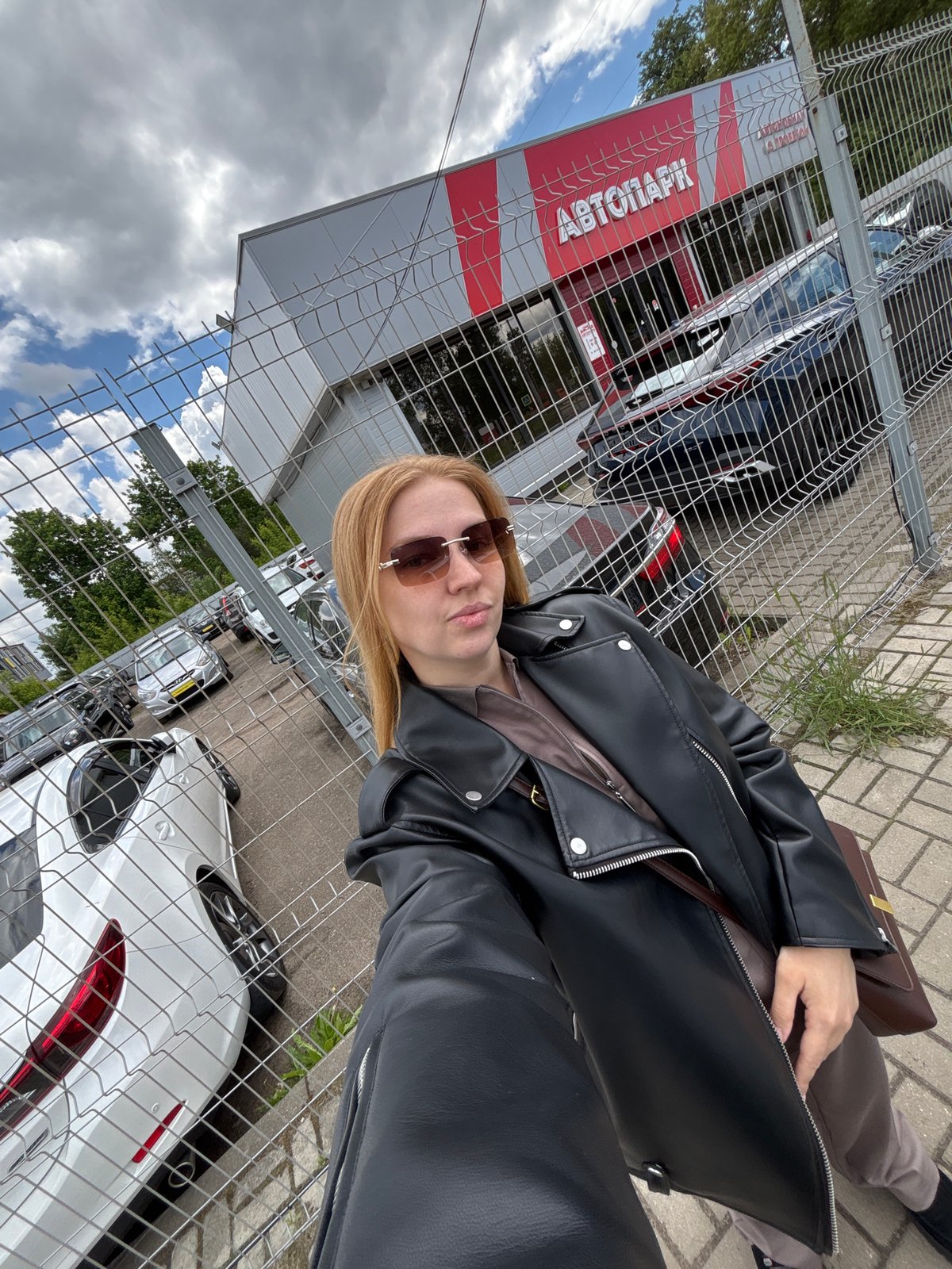 Woman sits on bench near autograph fence in Yaroslavl
