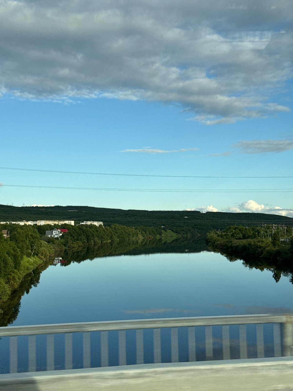 Driving through Zverosovkhoz along a calm Russian riverside