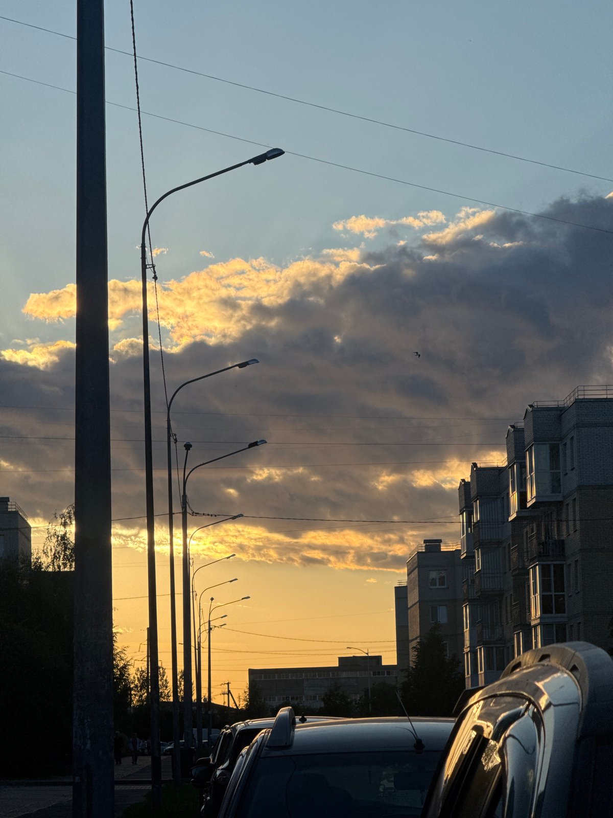 Sunset clouds over Shushary streets, golden light and silhouettes