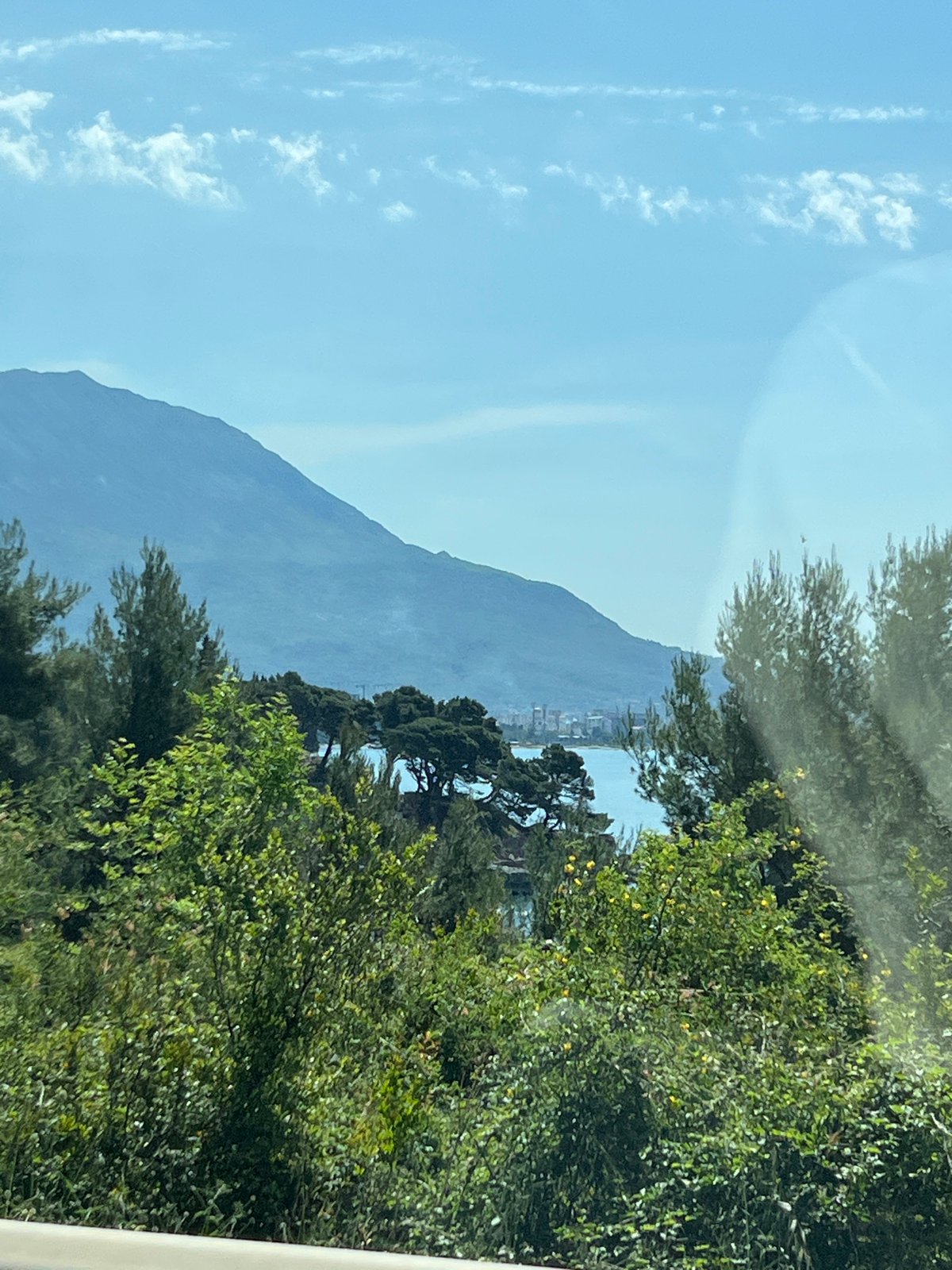 Coastal mountain view photographed through window in Sutomore