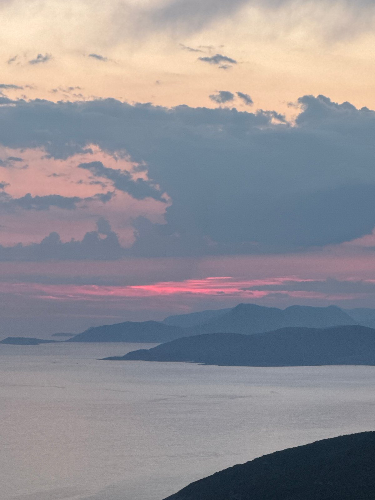 Sunset over Montenegro's coastal waters with mountain backdrop