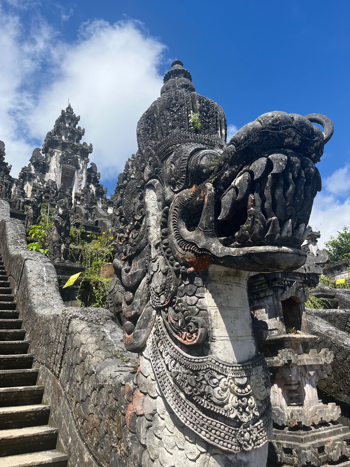 Temple visitor documents ancient Balinese architecture and mountain views