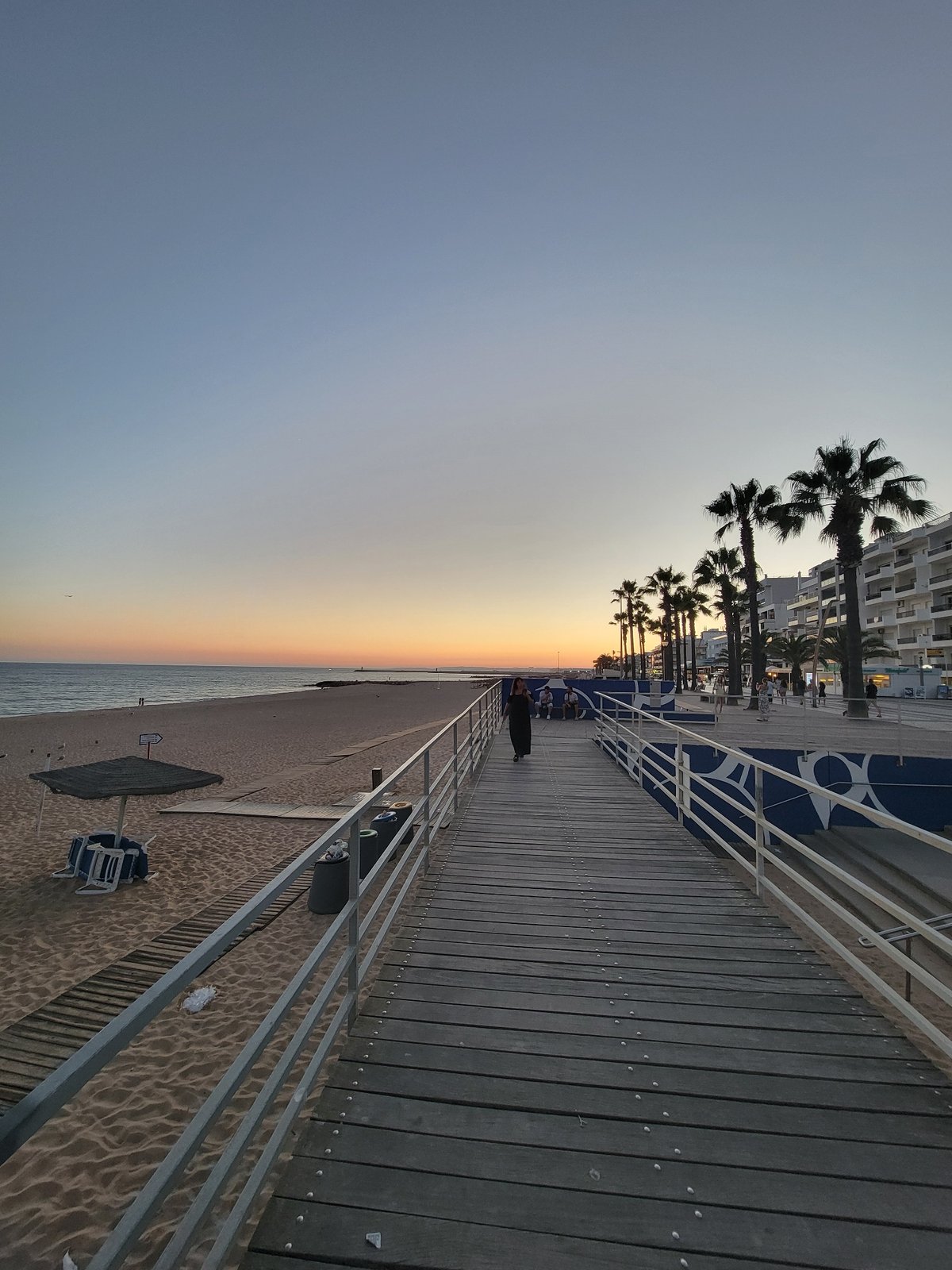 Quarteira beach and promenade at sunset, July evening