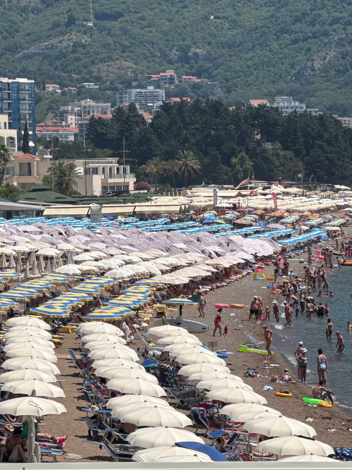 Summer morning on the Budva Riviera — beaches, boats, and paragliders