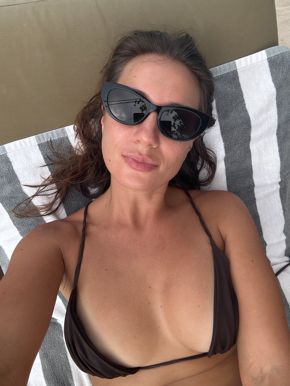 Woman enjoys morning beach time with beer in Indonesia