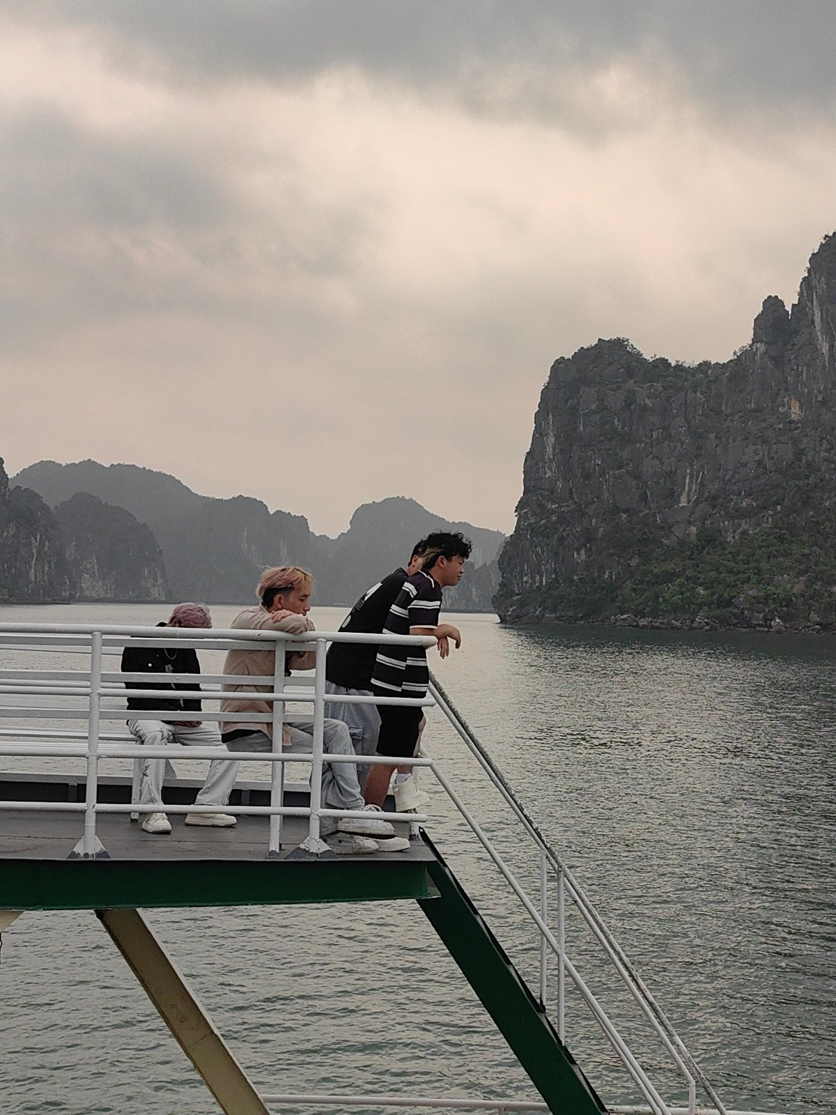 Young travelers observe landscape from boat deck in Vietnam