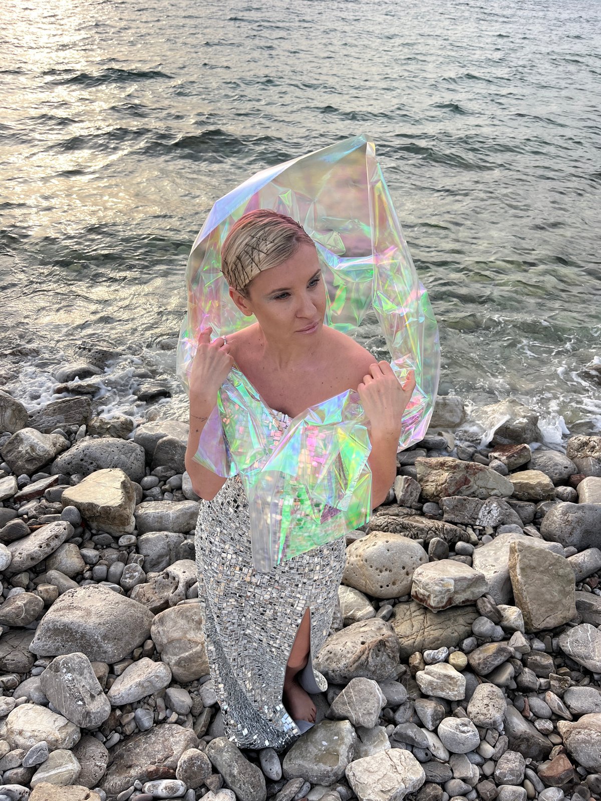 Woman poses on rocky beach in Buljarica, Montenegro