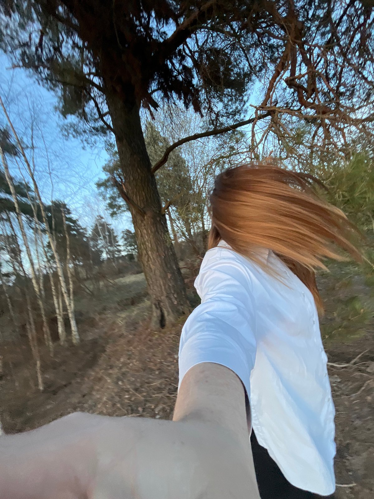 Woman takes forest selfies at sunset in Раздолье, Russia