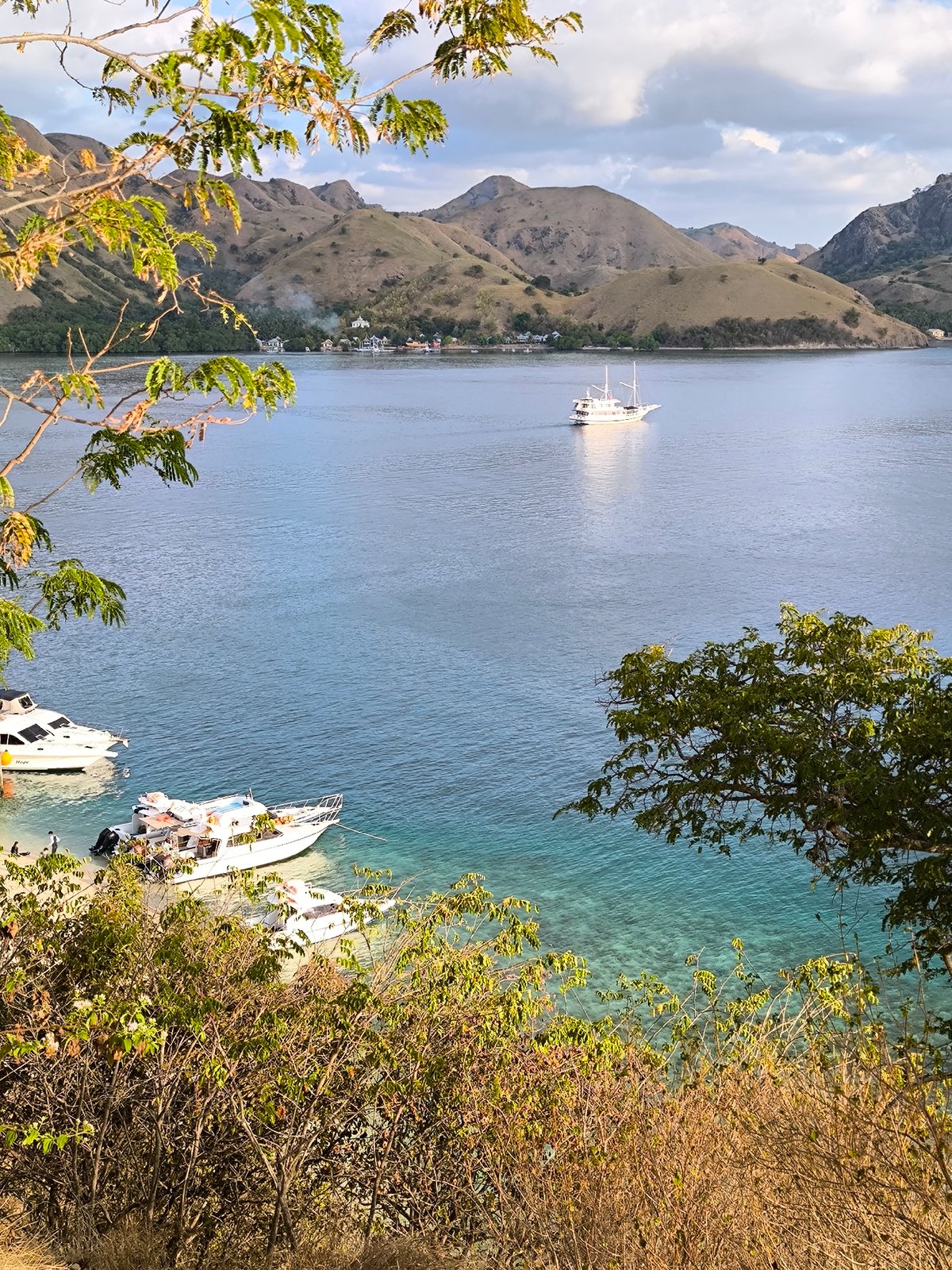 Two-masted sailboat cruises calm Indonesian coastal waters