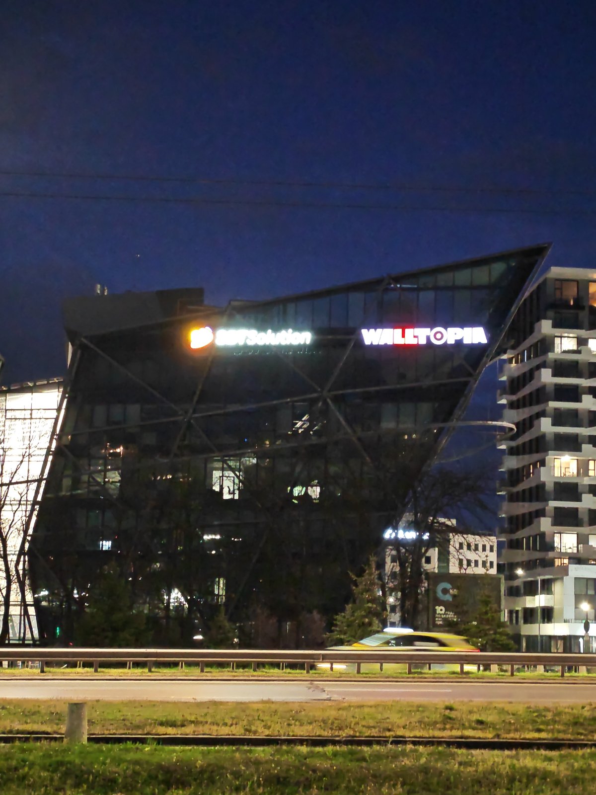 Commercial buildings illuminate Sofia business district at evening